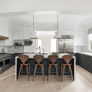 Contemporary kitchen featuring white cabinets, dark accents, and a central island with bar stools.