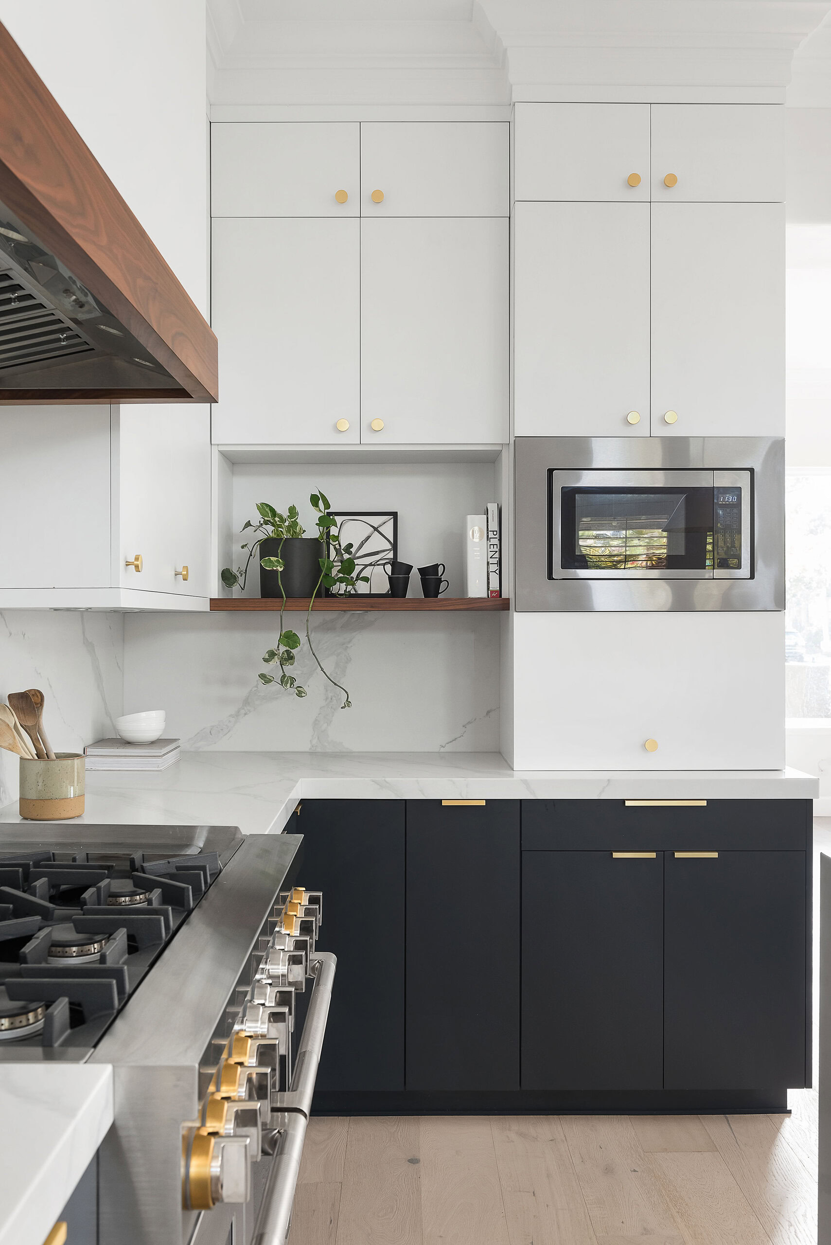 Stylish kitchen featuring white upper and navy lower cabinets with gold accents.