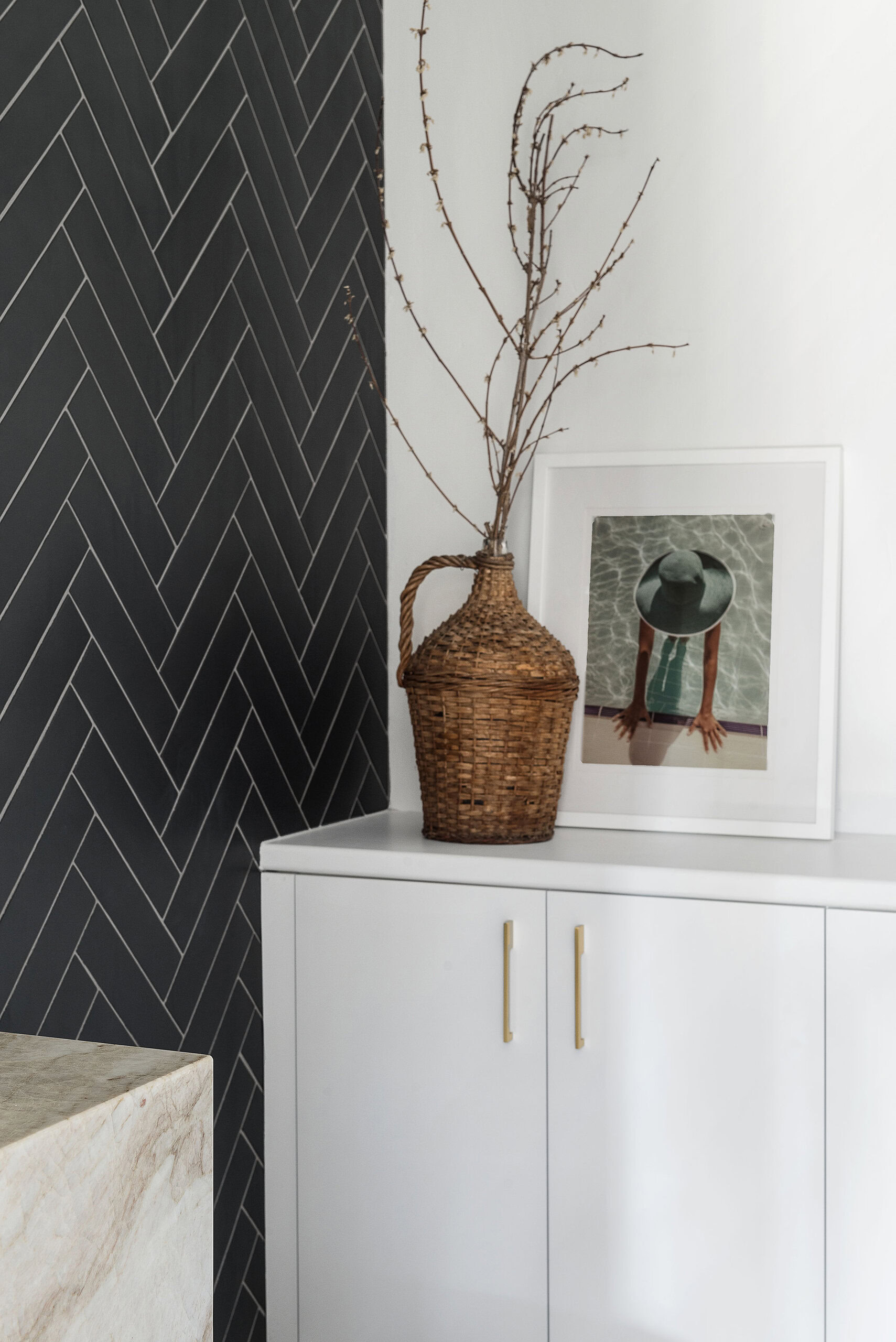Elegant interior design featuring a black herringbone wall and stylish decorative elements.