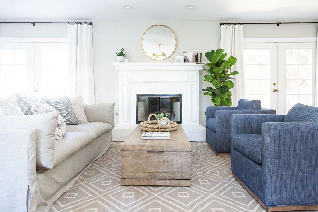 Elegant living room with blue sofas and white accents, showcasing interior design expertise.