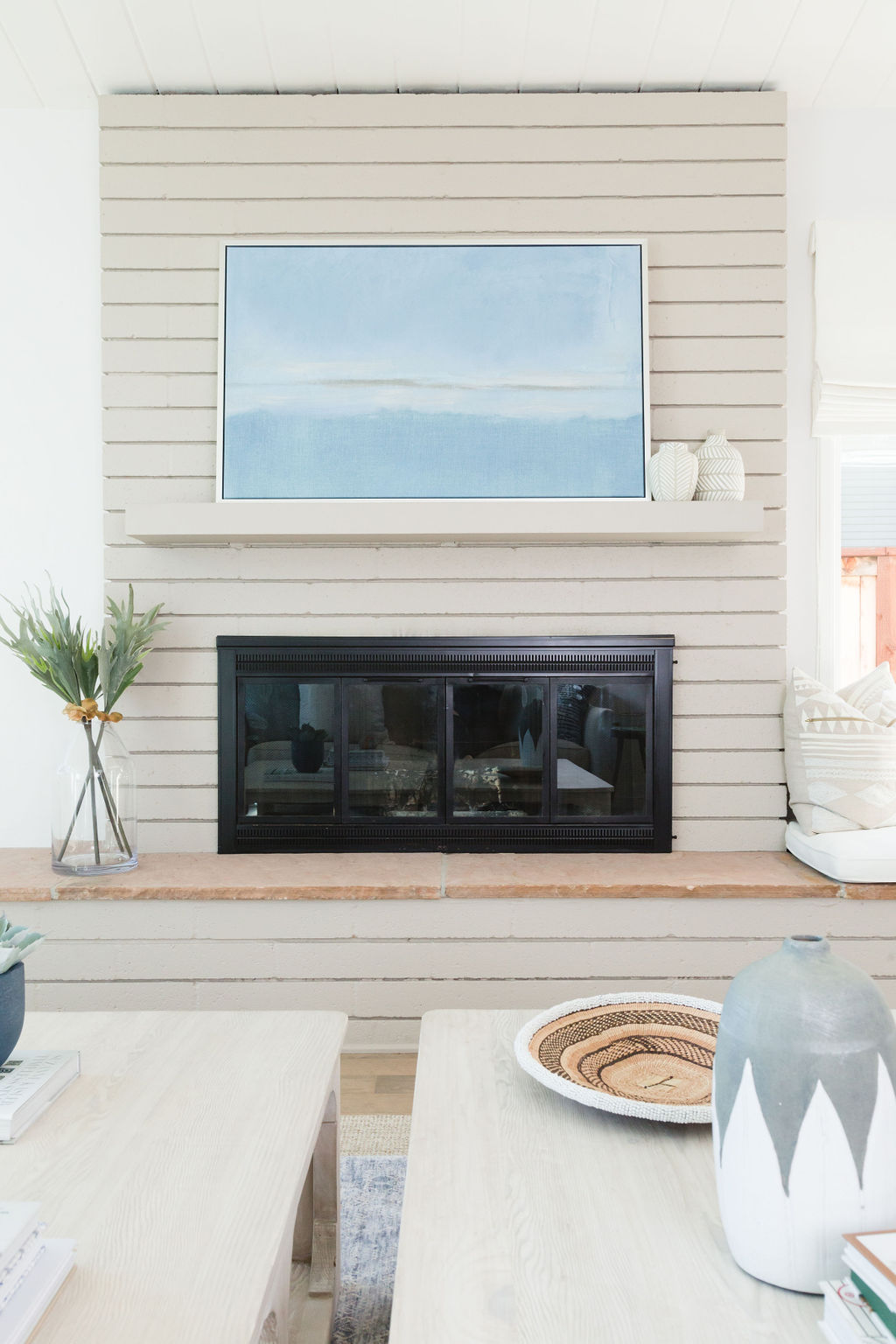 Blue wall art above fireplace enhances interior decor with calming color.