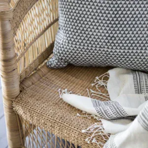Rattan chair with patterned cushion and throw blanket, perfect for summer outdoor upgrades.