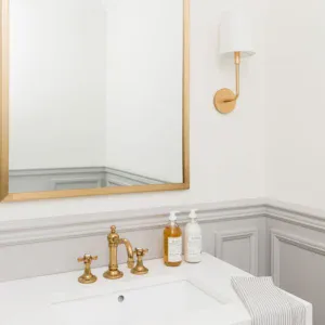 Bathroom interior with stylish gold faucet and minimalist design.