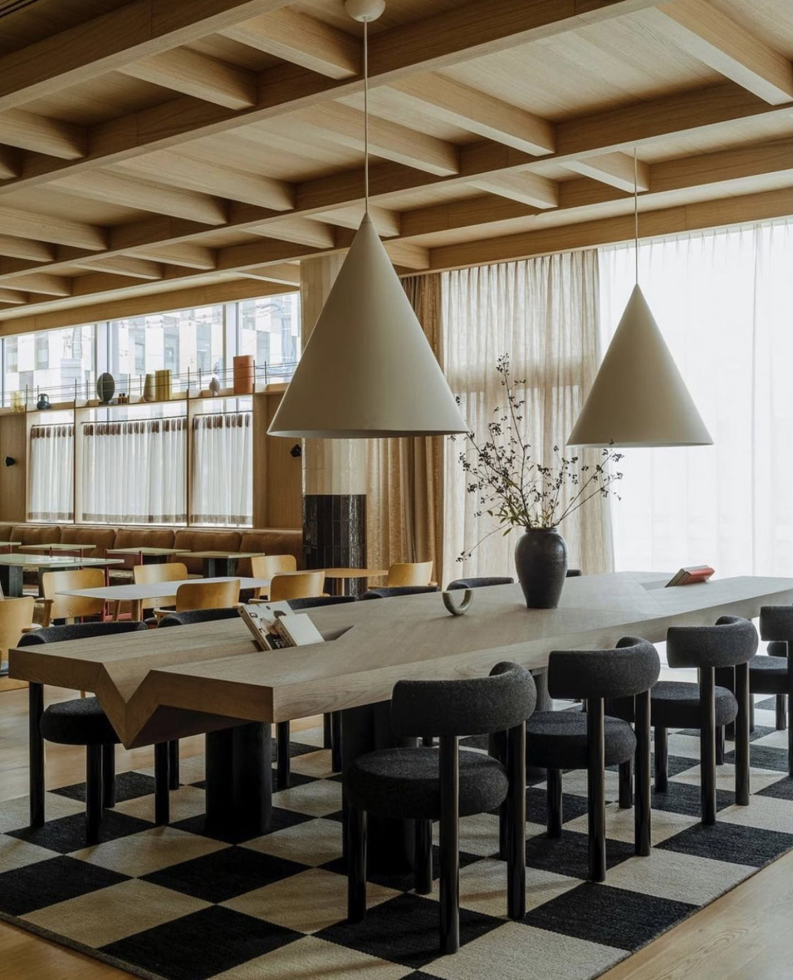 Elegant dining space featuring contemporary furniture and large windows for a bright, inviting atmos.