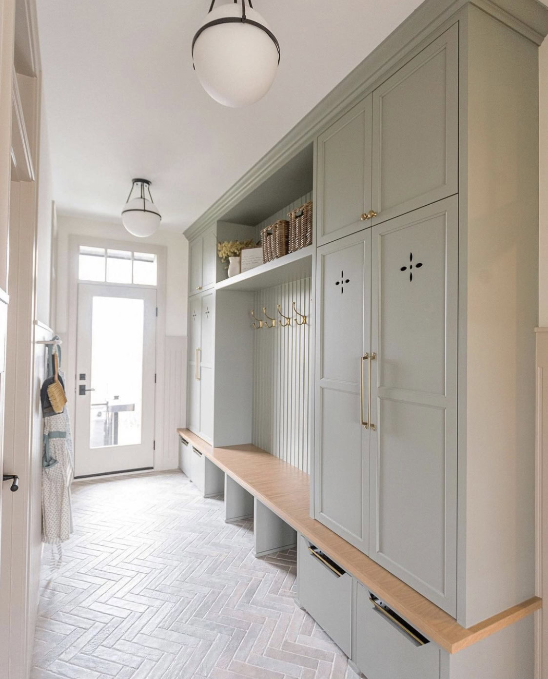 Green storage cabinet with integrated bench and hooks, ideal for stylish and functional home organiz.