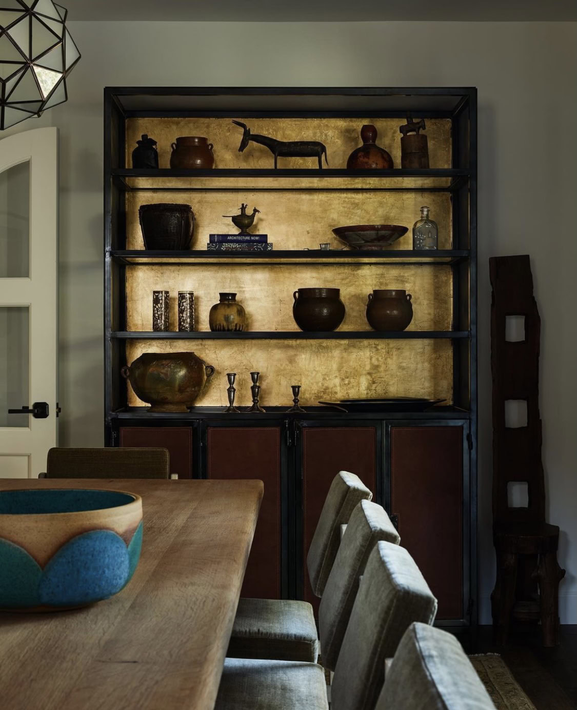 Elegant black display cabinet with antique pottery and decorative items.