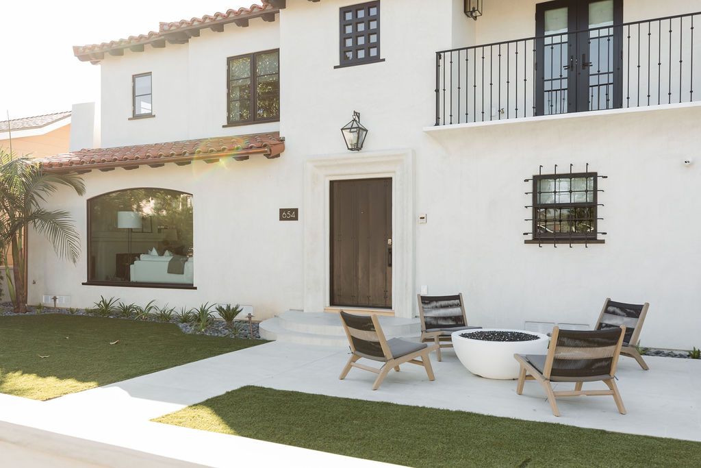 Beautiful white Spanish-style house with outdoor seating and garden.