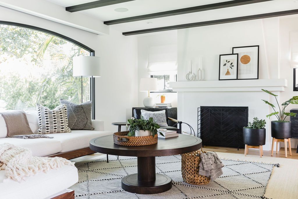 Contemporary living room interior with white walls, large window, and stylish decor.