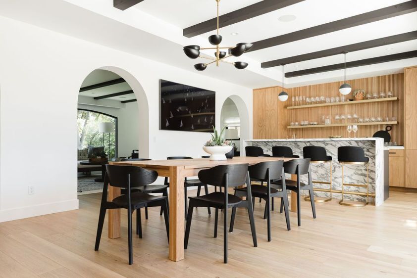 Contemporary dining area with wooden accents and open-plan kitchen design.