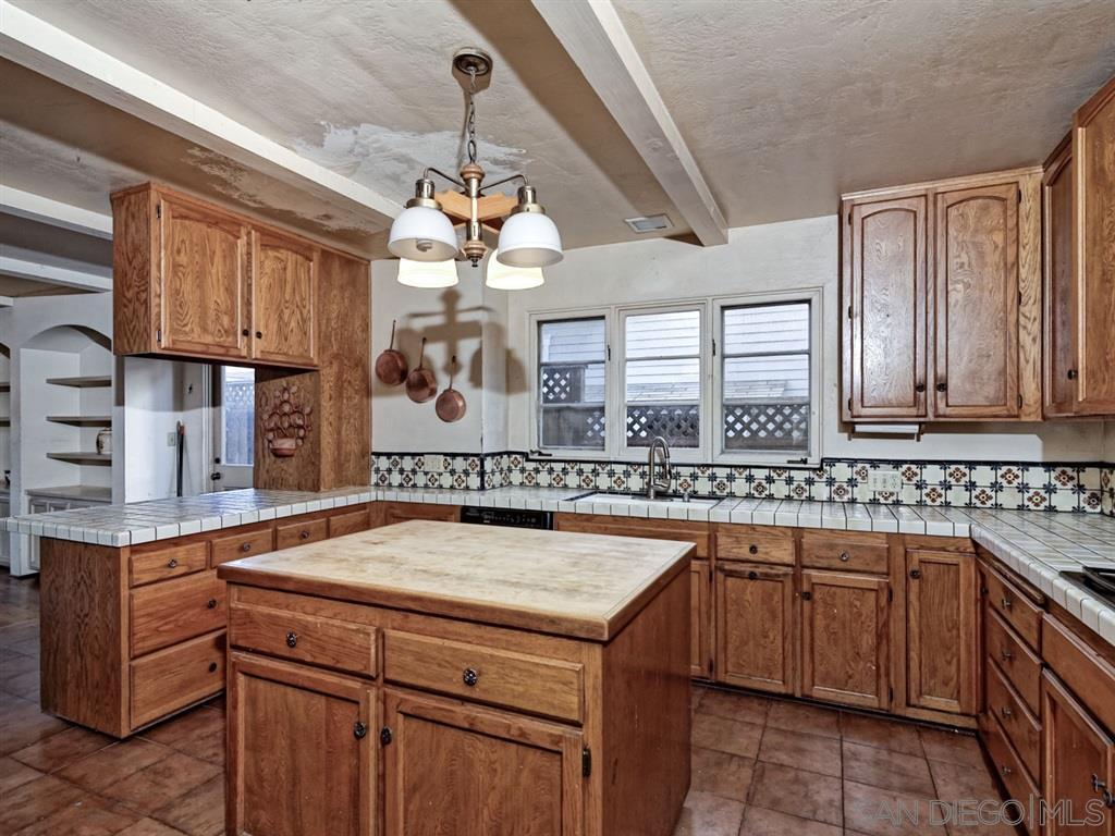 Kitchen with wooden cabinets and island, bright natural light, before & after project.