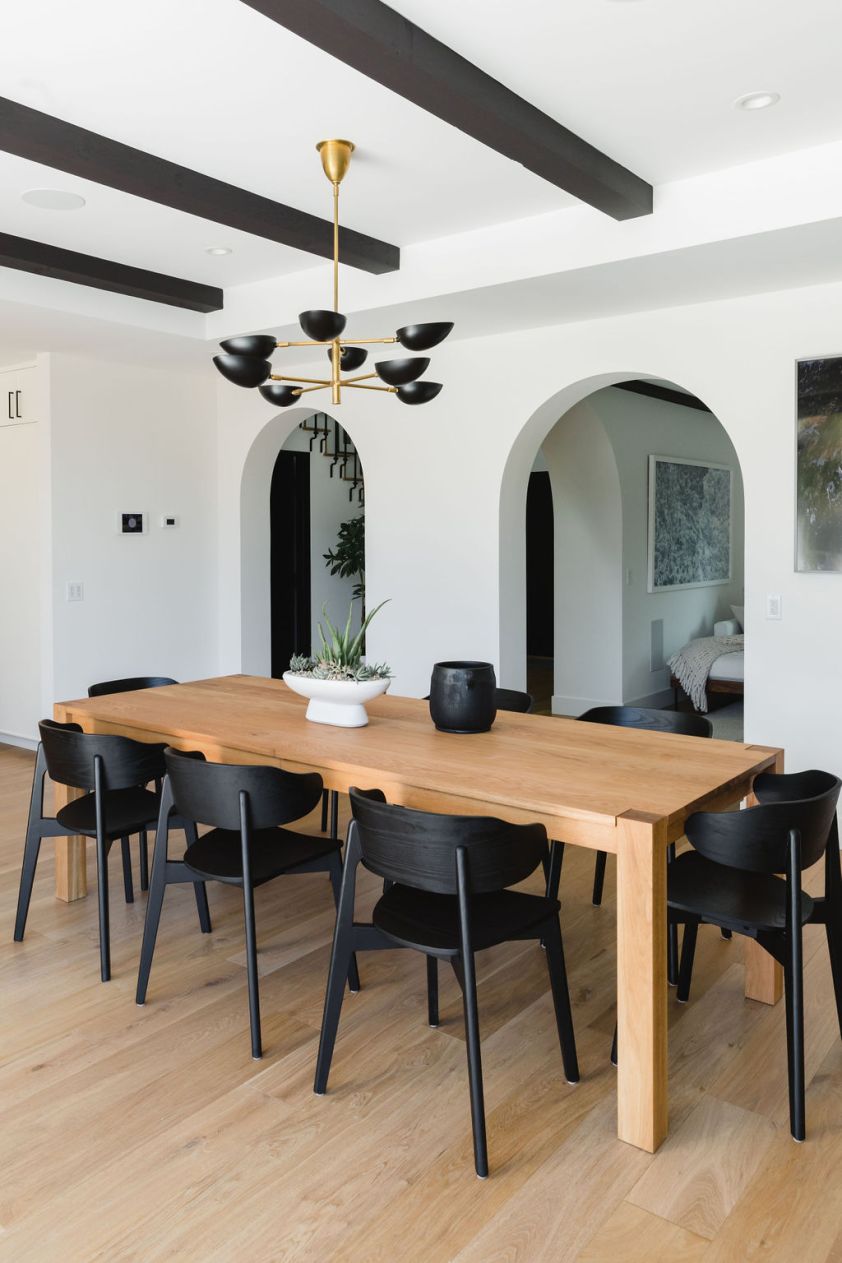 Stylish dining area featuring black chairs and a wooden table, showcasing South Harlow Interiors' in.