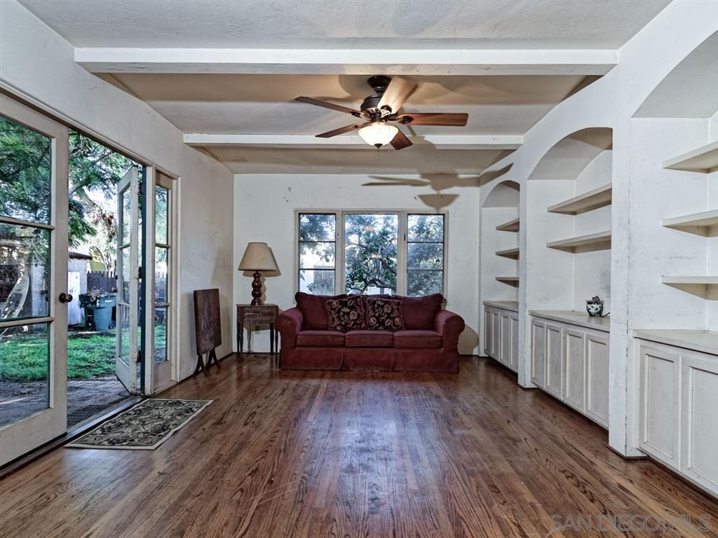 Interior of a living room with a red sofa and wooden flooring.