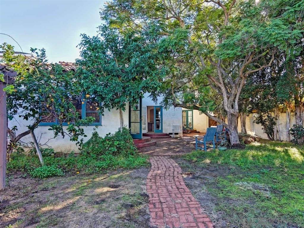 Outdoor garden with brick pathway and mature trees.