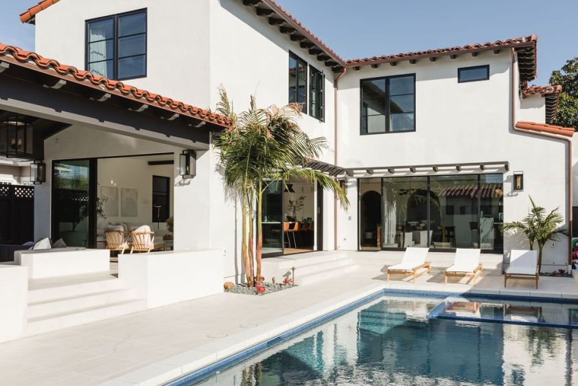 Elegant Spanish-style home renovation with pool and outdoor lounging area.