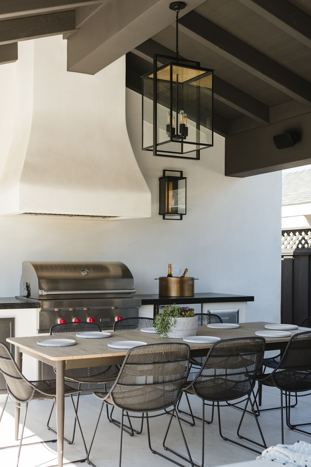 Outdoor kitchen with grill and dining table for entertaining guests.