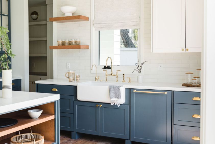 Stylish blue kitchen with white countertops and gold hardware, perfect for contemporary interior des.