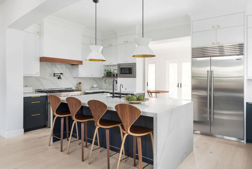 Elegant kitchen design featuring white cabinetry, navy details, and a spacious island.