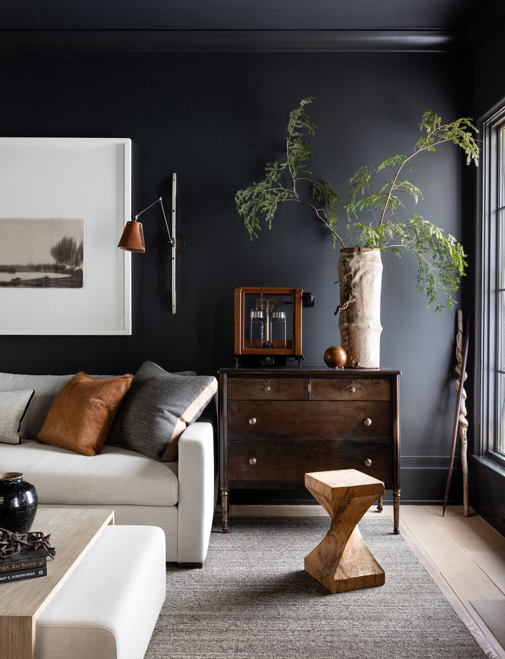 Interior living room with modern decor, dark walls, and a creative ceiling interest feature.