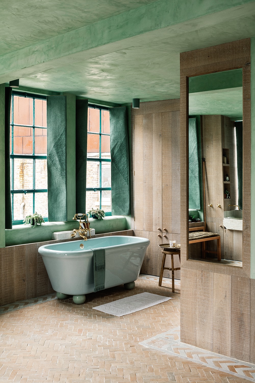 Elegant bathroom featuring a green ceiling, large windows, and a freestanding bathtub.
