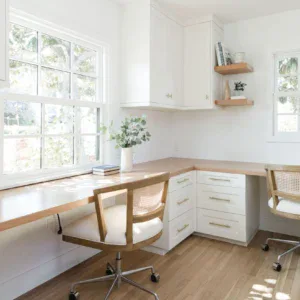 Bright white office desk with ergonomic chairs in a sunny workspace.