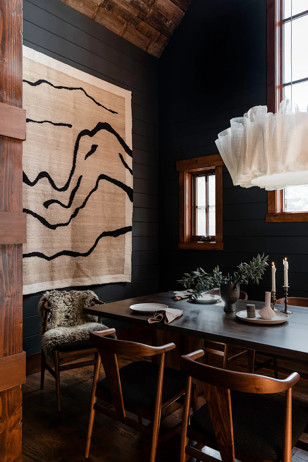Dark paint wall with abstract art in a cozy dining space.