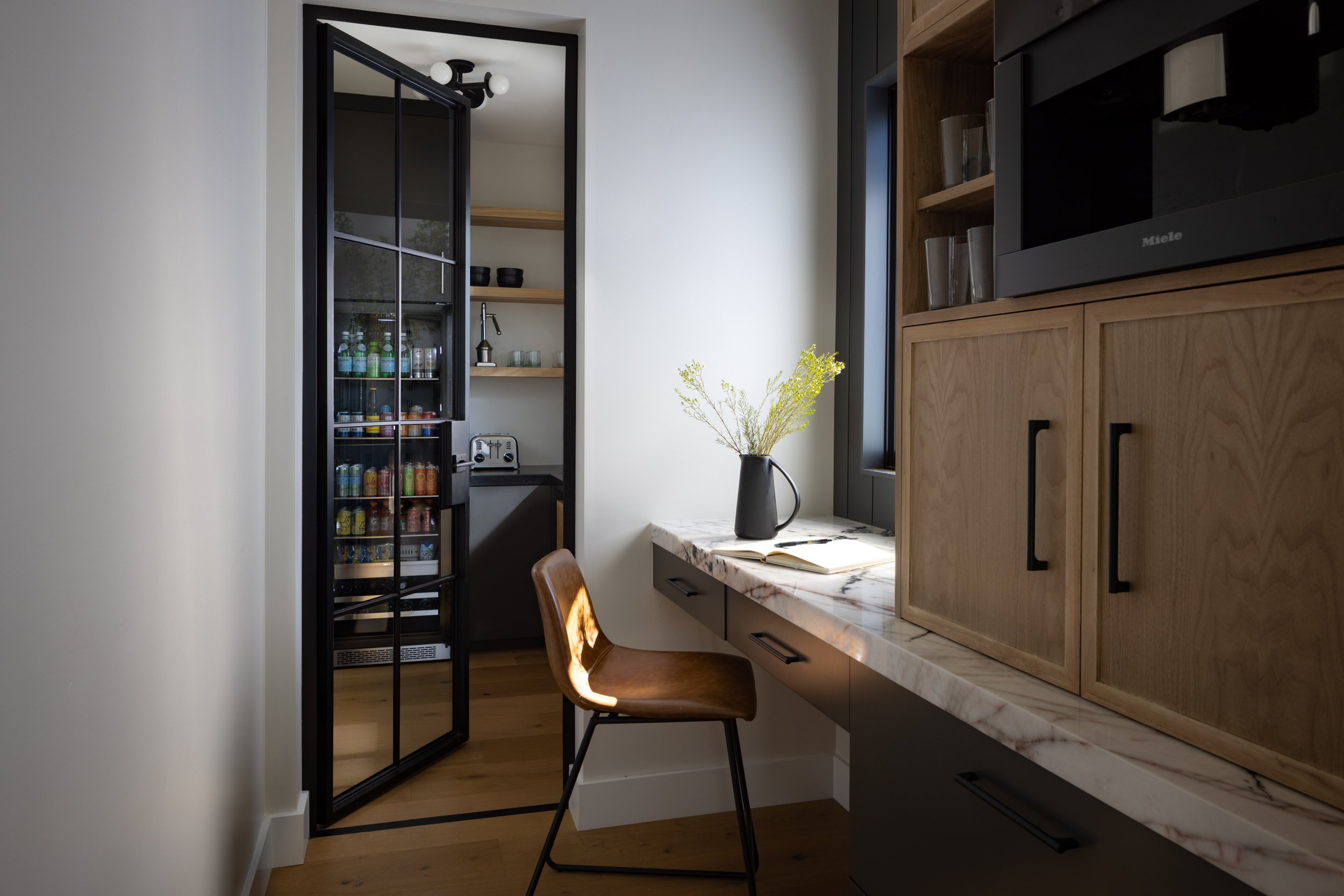 Modern kitchen interior with wooden cabinetry and a small workspace.