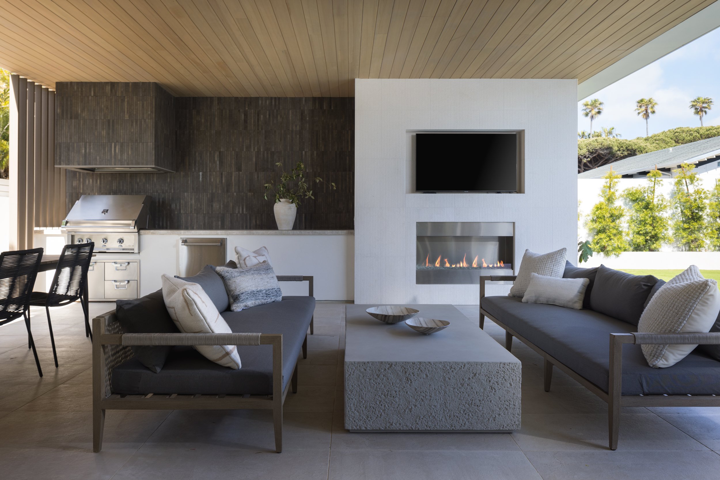Elegant outdoor lounge area featuring contemporary furniture and a sleek fireplace for relaxing even.