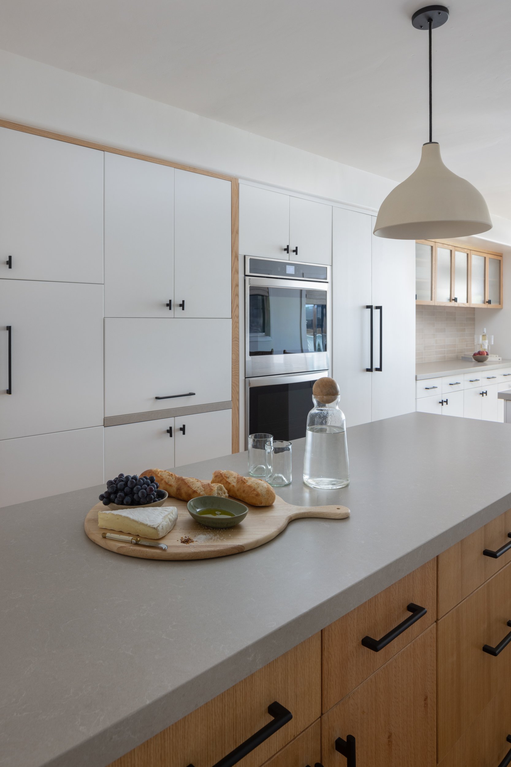 Modern kitchen with sleek white cabinetry and natural wood accents.