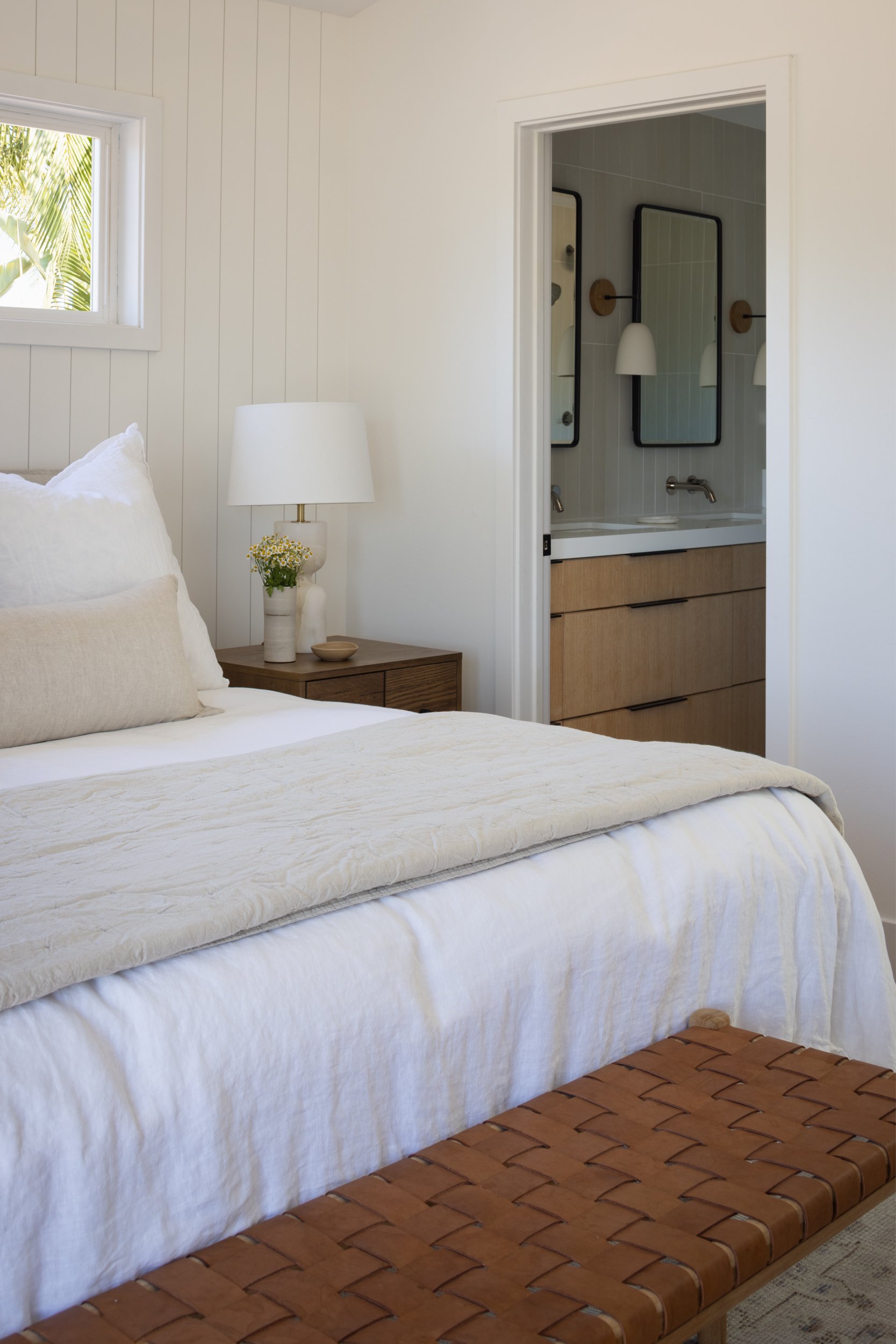 Modern coastal bedroom with white walls and natural light.