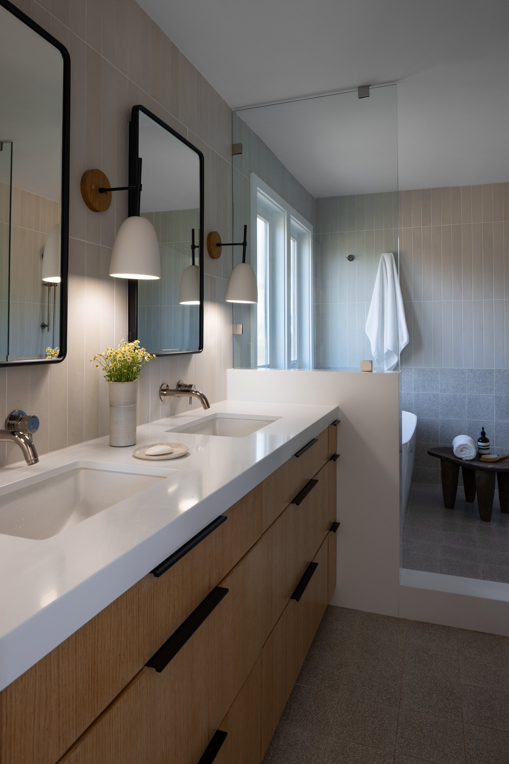 Elegant bathroom featuring a double vanity, large mirrors, and soft lighting for a relaxing atmosphe.