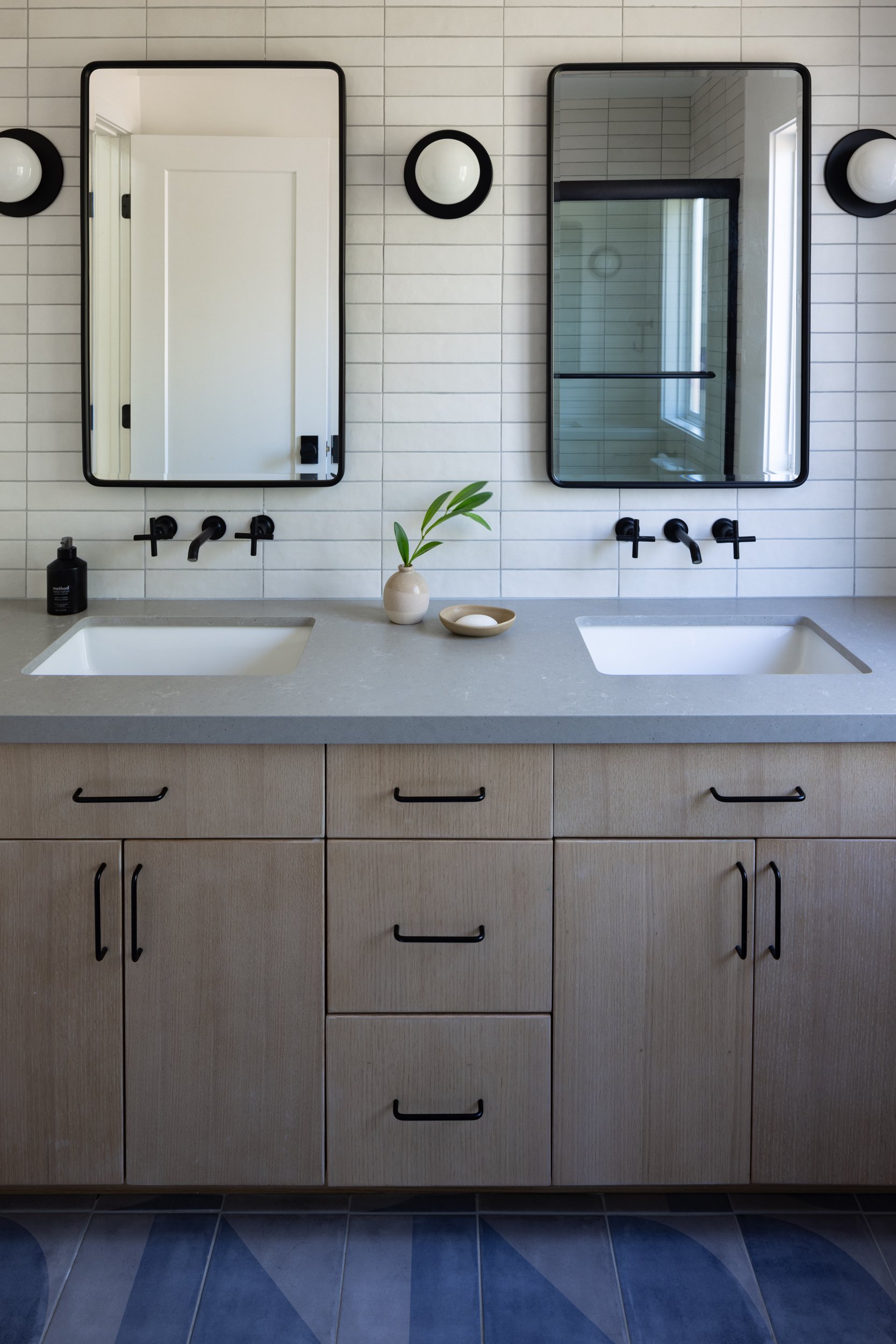 Elegant bathroom with dual sinks, stylish mirrors, and contemporary decor for a sleek, functional sp.