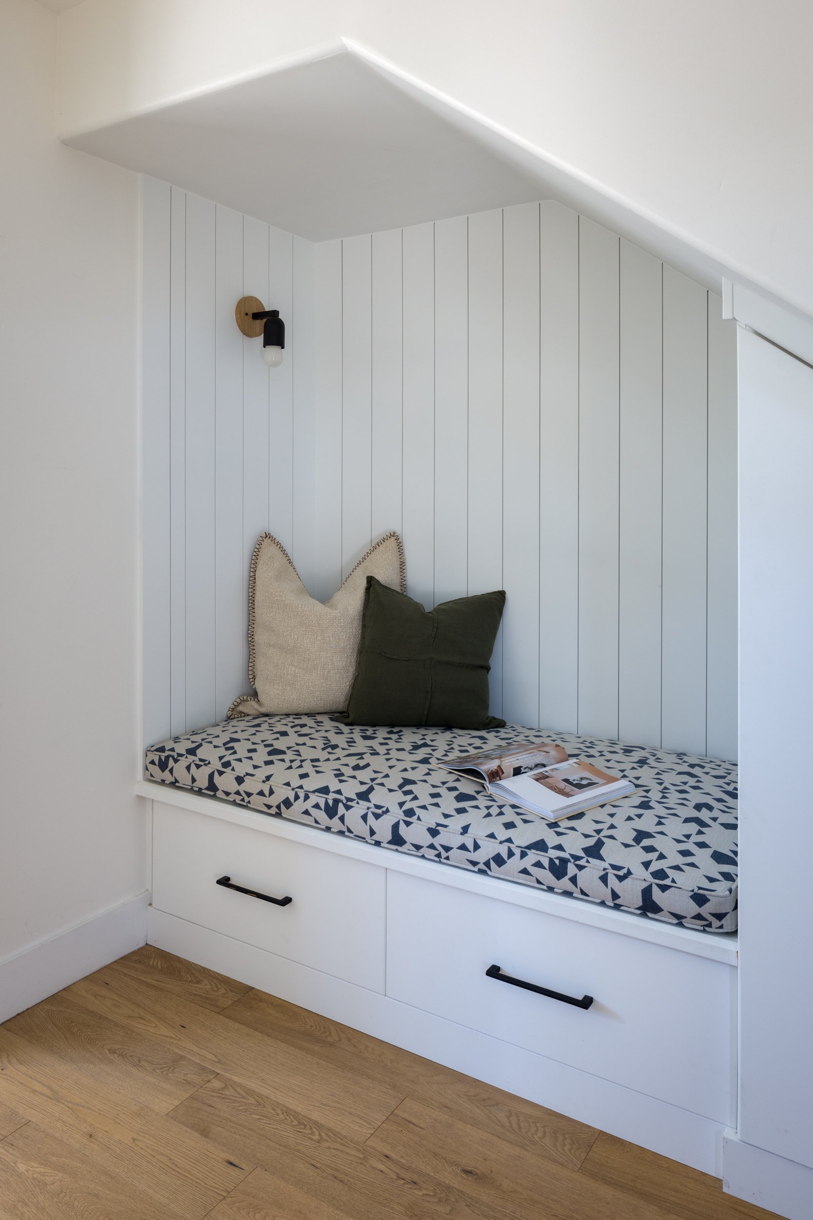 Built-in window seat with cushions in a modern interior.