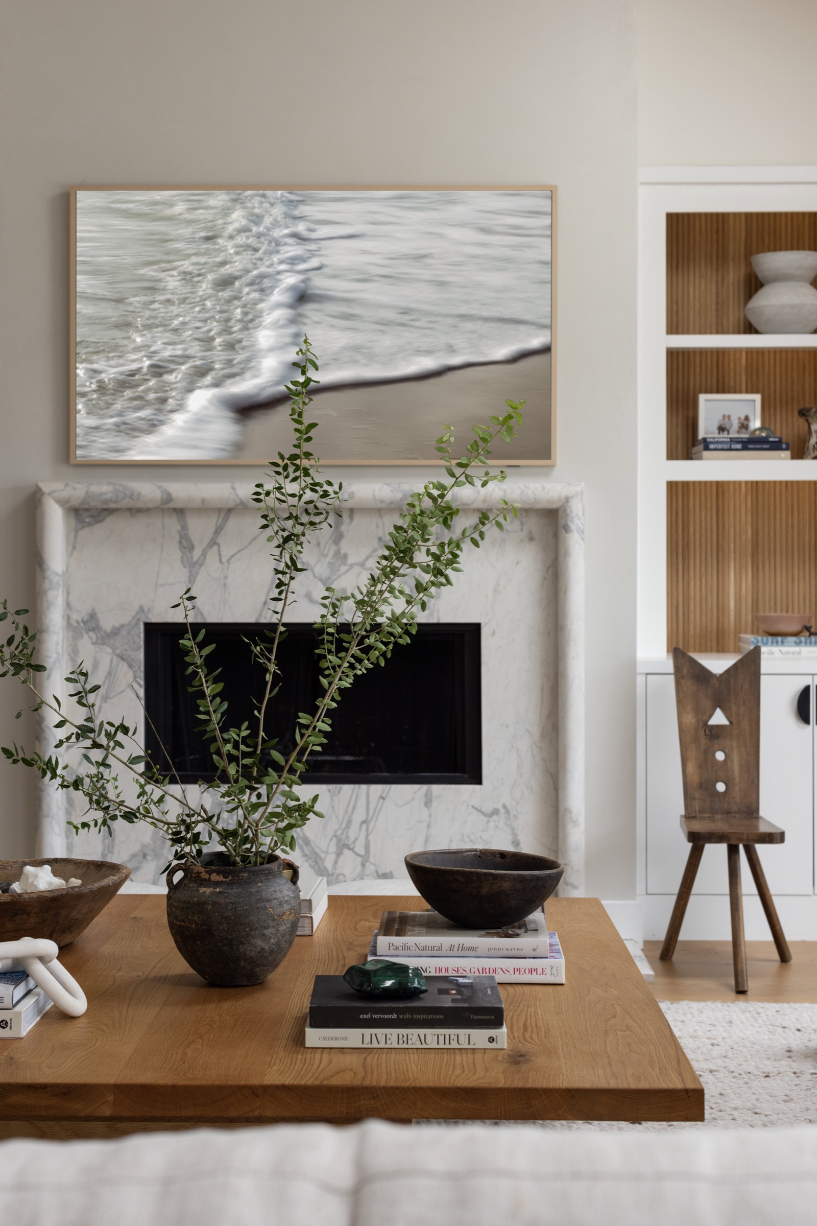 Modern living room with beach-inspired artwork and natural decor elements.