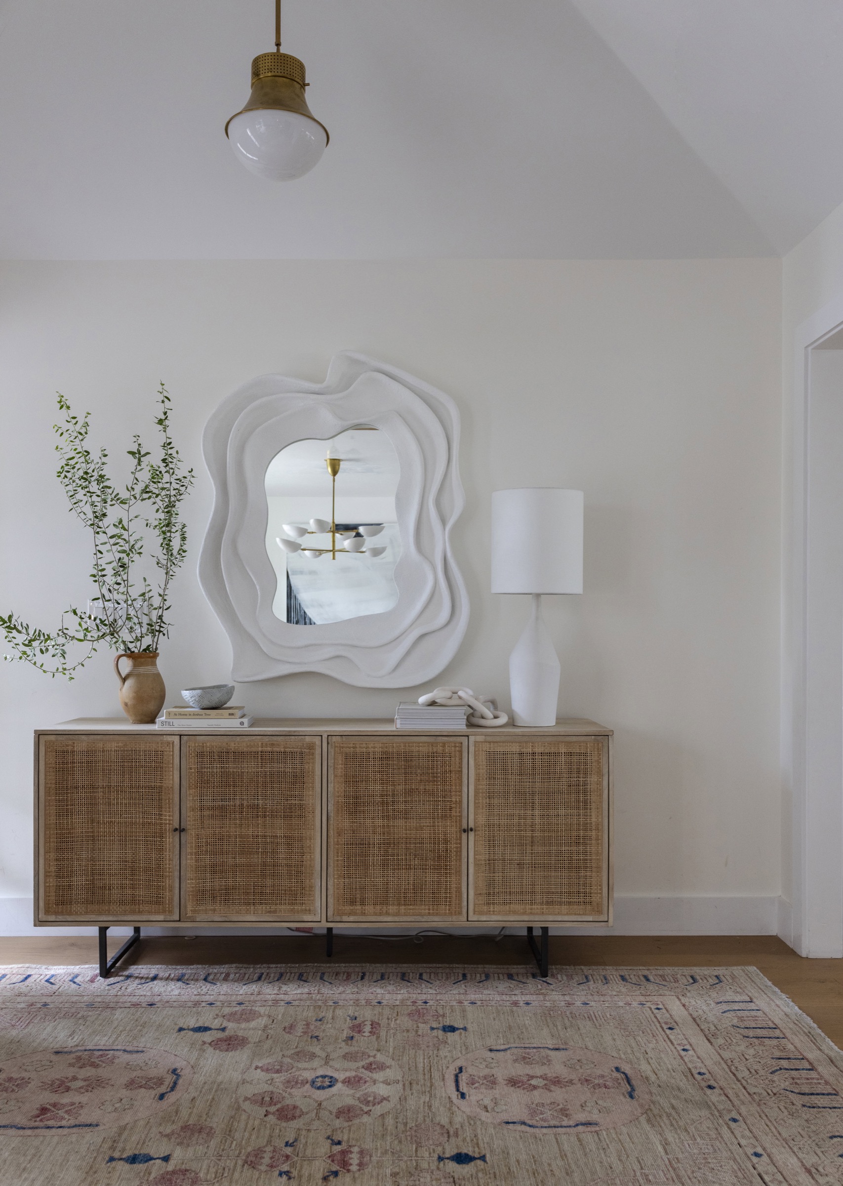 Elegant coastal-inspired interior with mirror, sideboard, and decor accents.