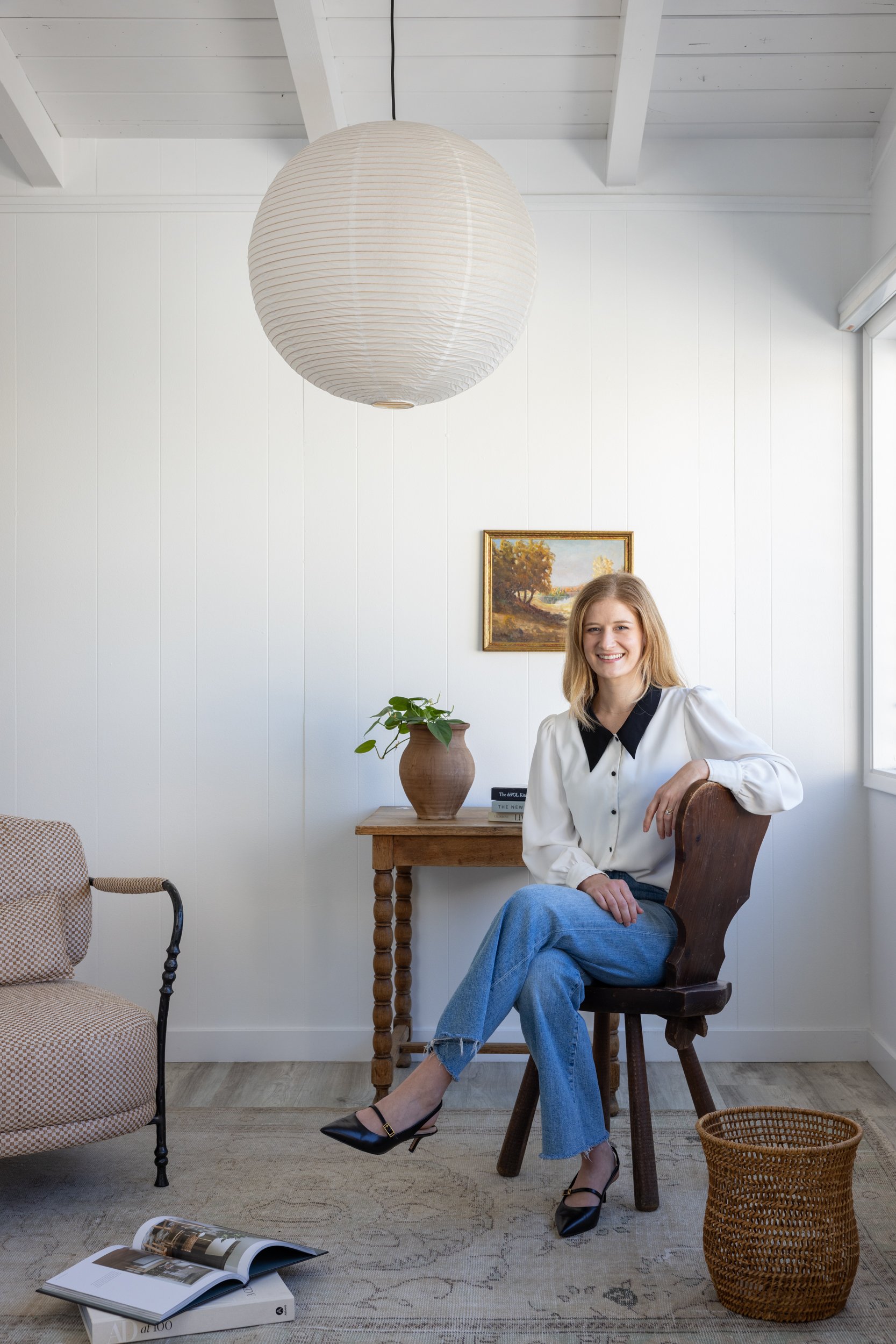 Woman sitting in a stylish, modern interior with team-focused decor at South Harlow Interiors.