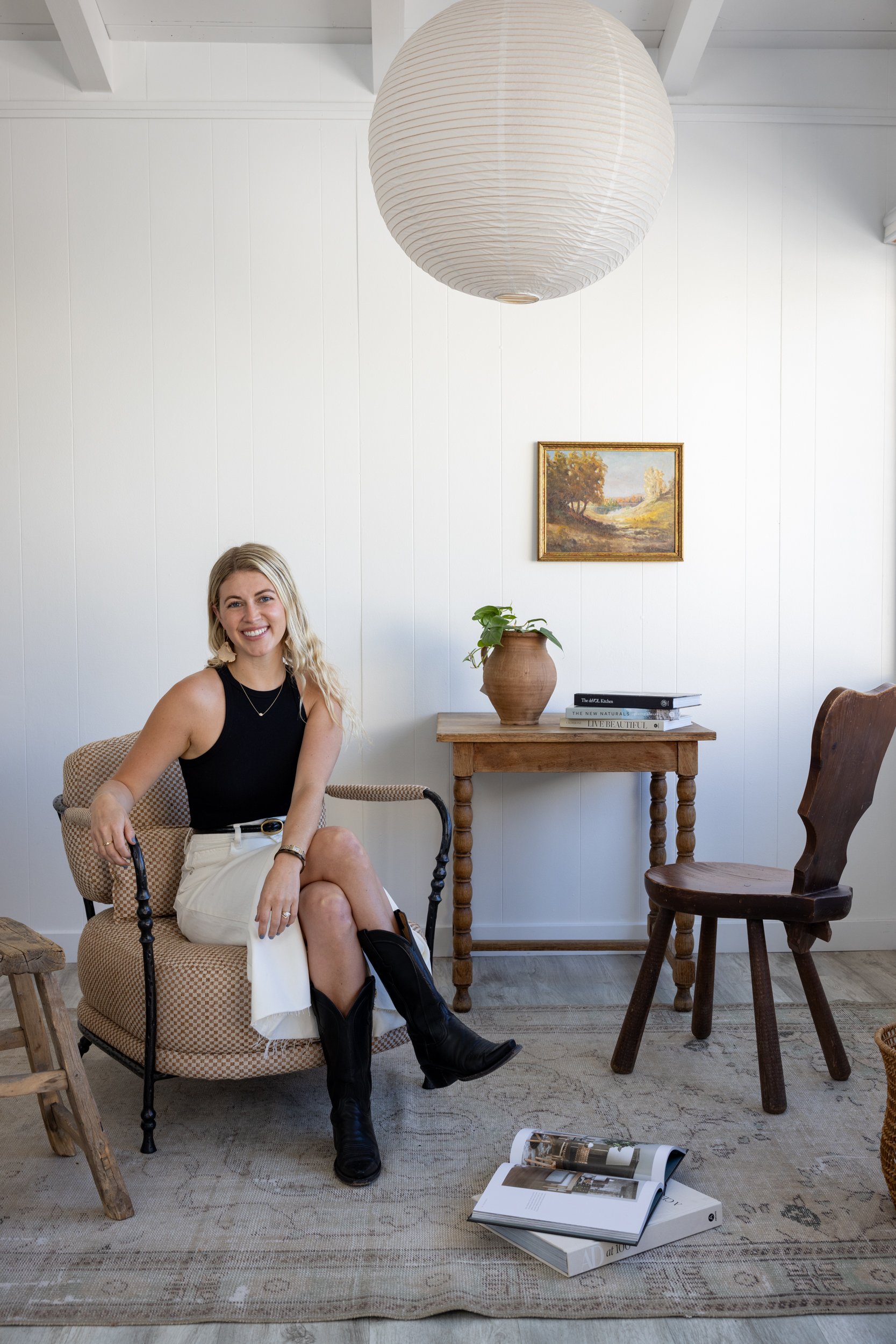 Portrait of a smiling woman sitting in a cozy, modern interior with minimalist decor and natural lig.