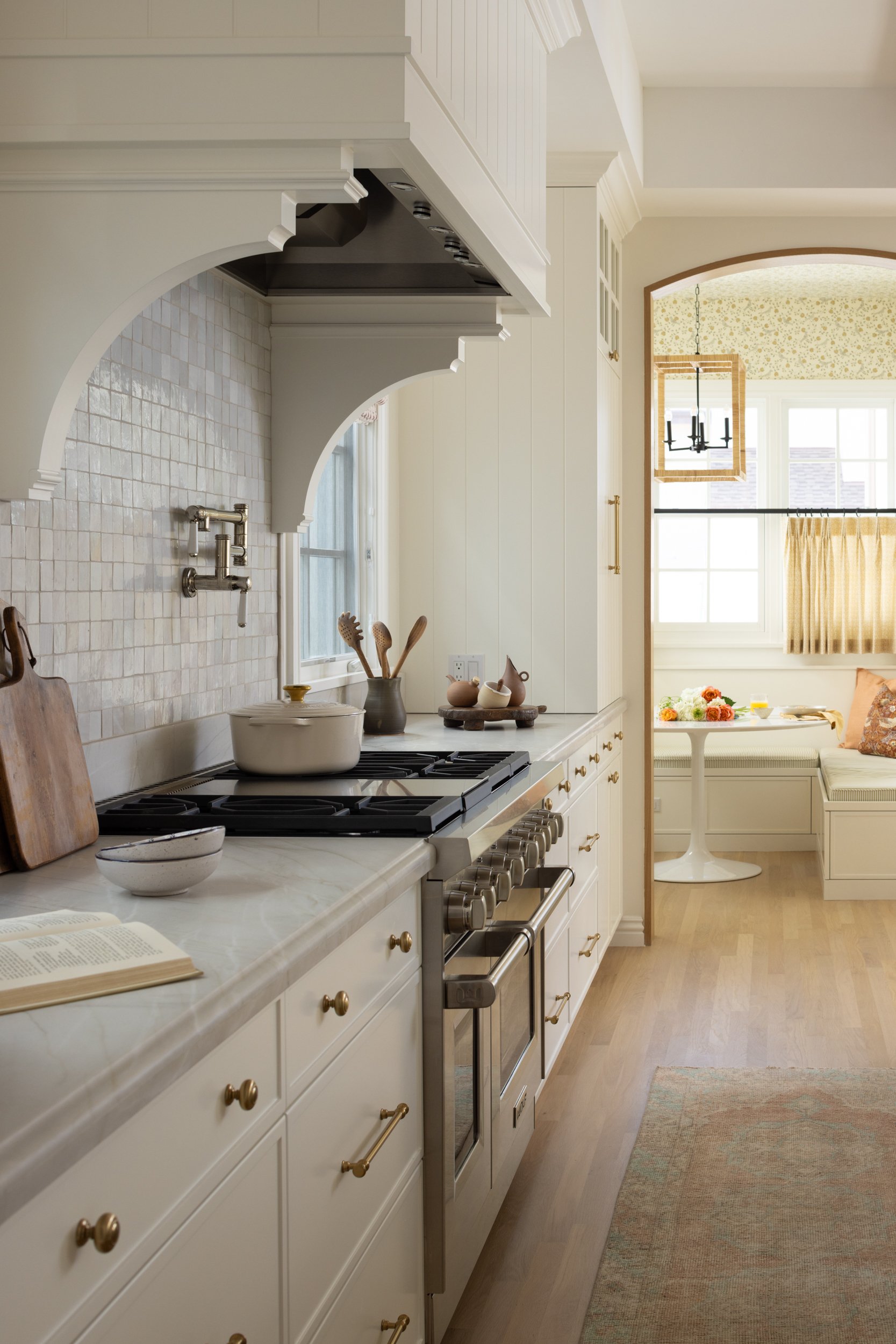 Bright white kitchen featuring vintage-style cabinetry and modern appliances. Perfect for a warm, in.
