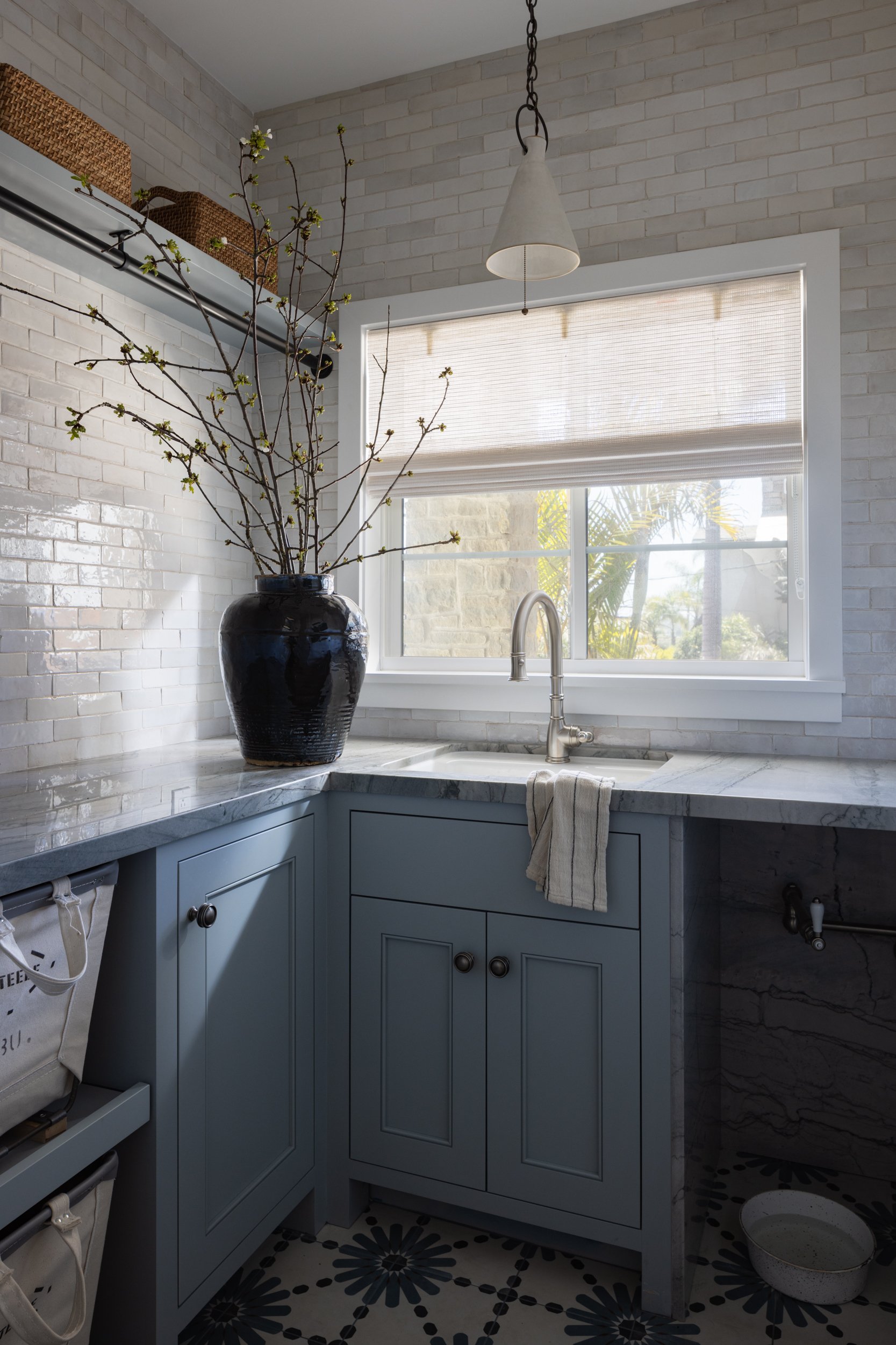 Bright kitchen featuring blue cabinets, a large window, and minimalist decor for a fresh look.