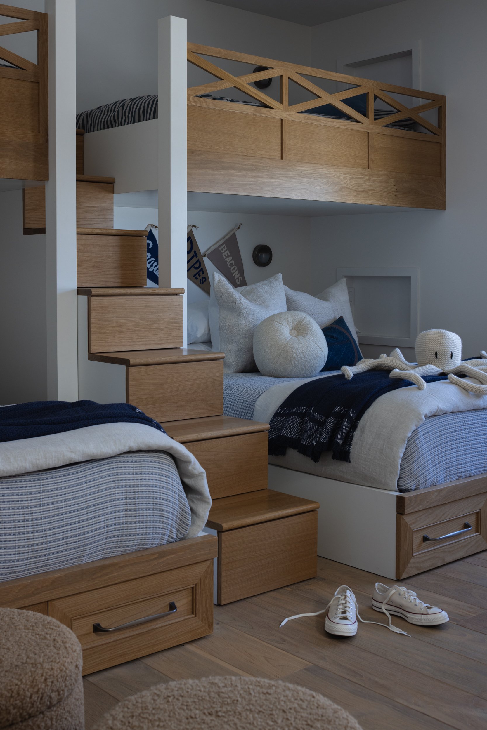 Bunk bed with storage drawers, cozy bedding, and a loft design in a child's room.