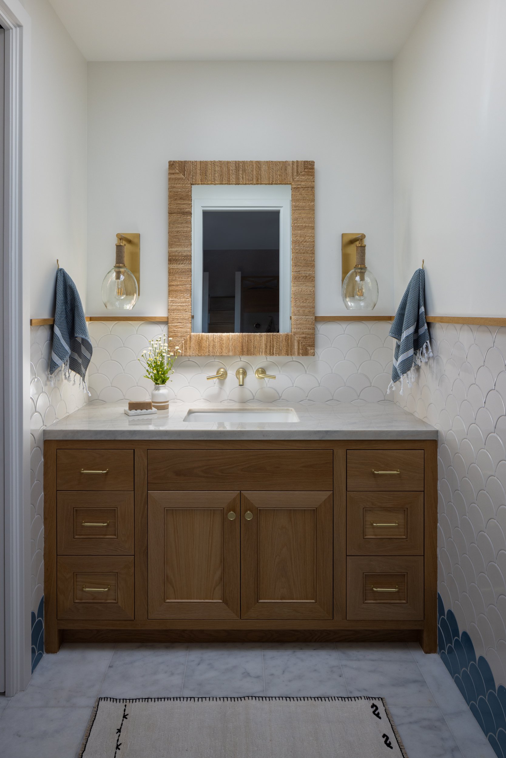 Elegant Neptune-inspired bathroom vanity with wooden cabinetry and modern lighting.