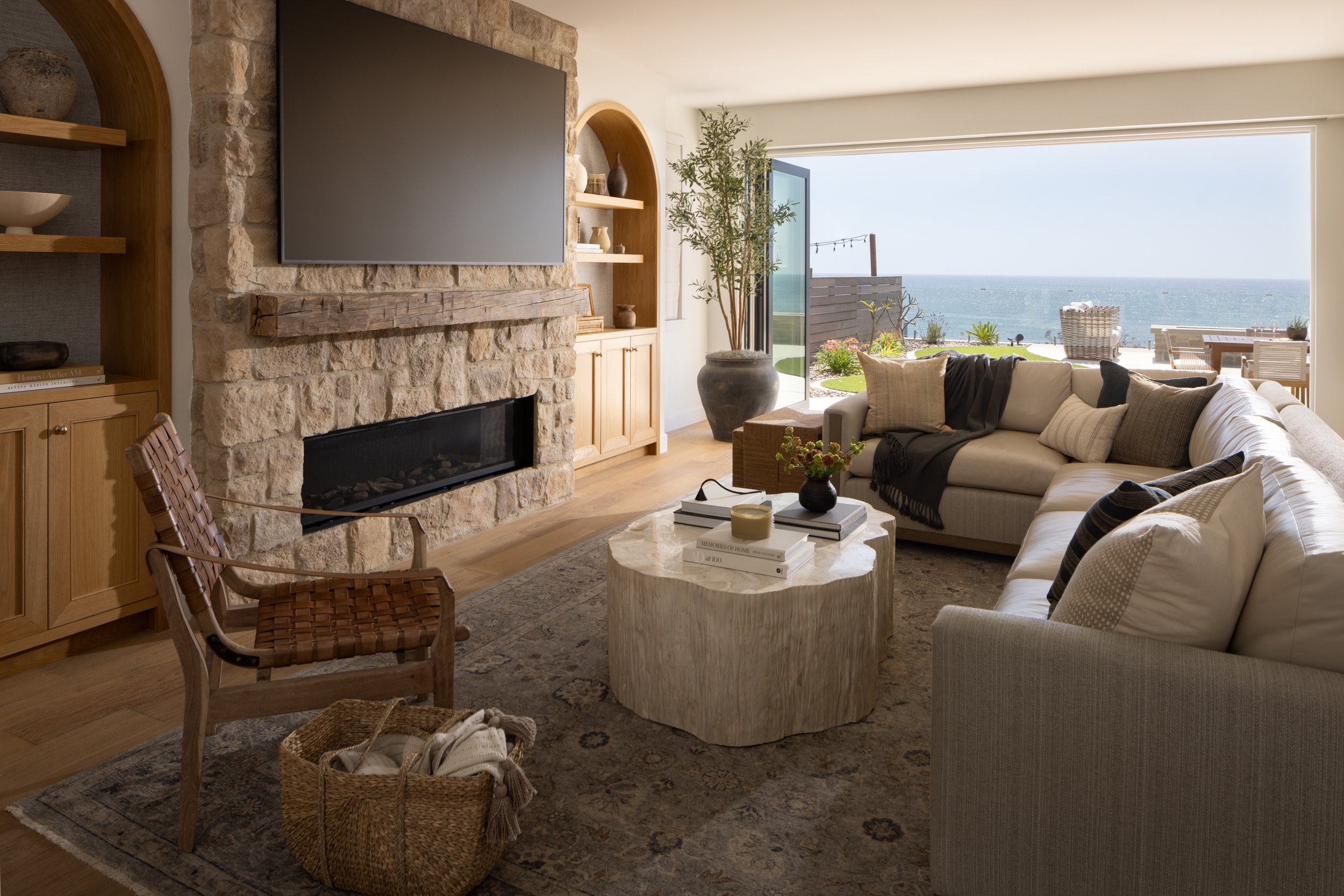Coastal living room interior with ocean view, stylish furniture, and natural decor.