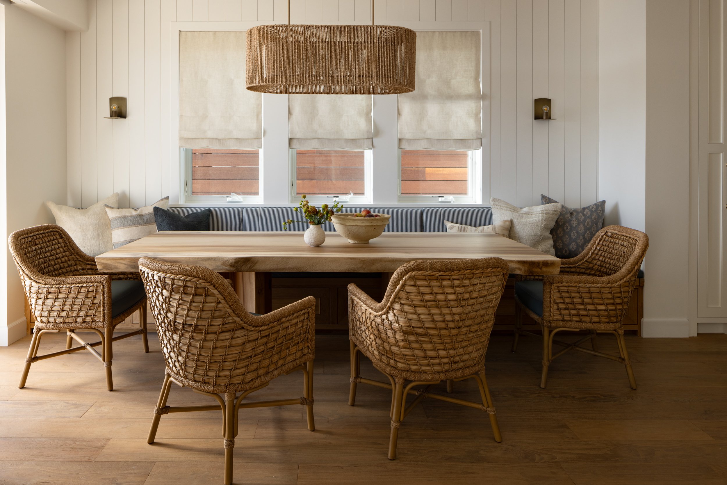 Coastal dining room featuring Neptune-themed decor with wicker chairs and soft neutral tones. Perfec.