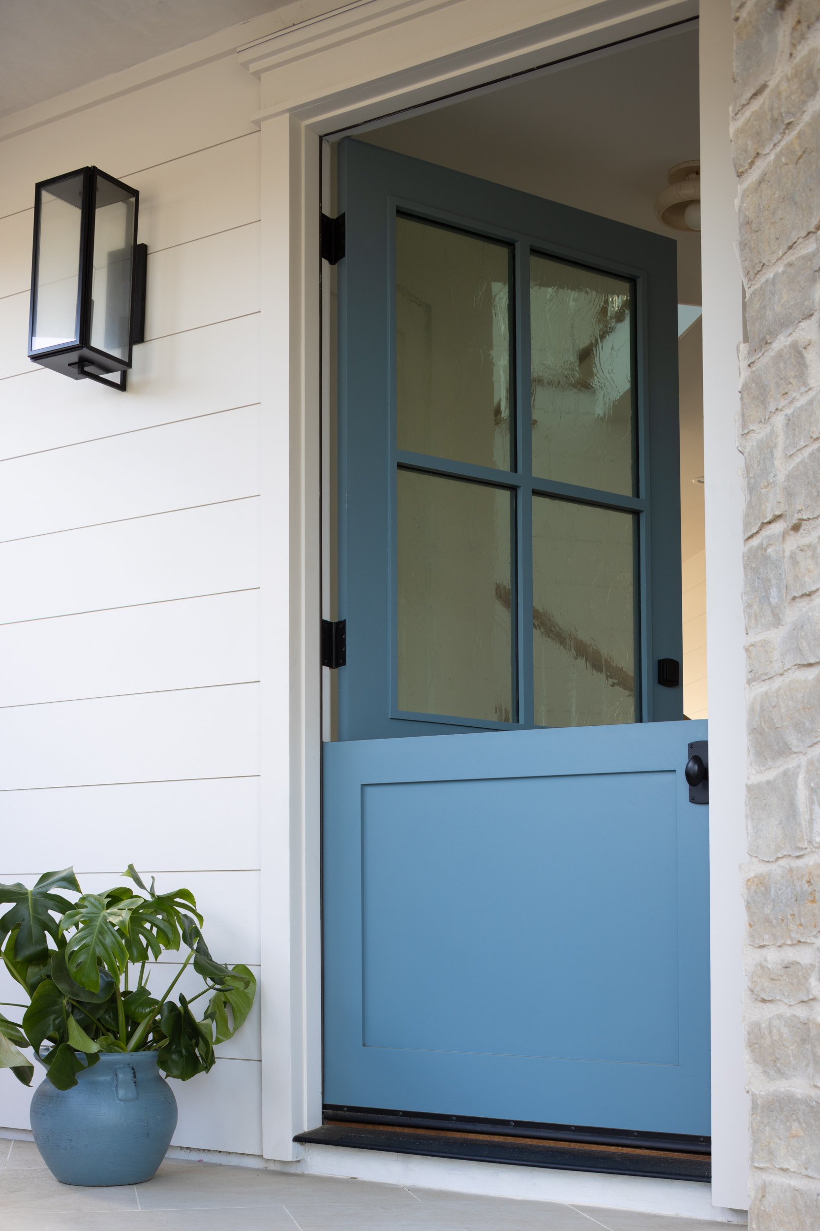Blue Neptune-inspired front door with glass panels and black hardware.