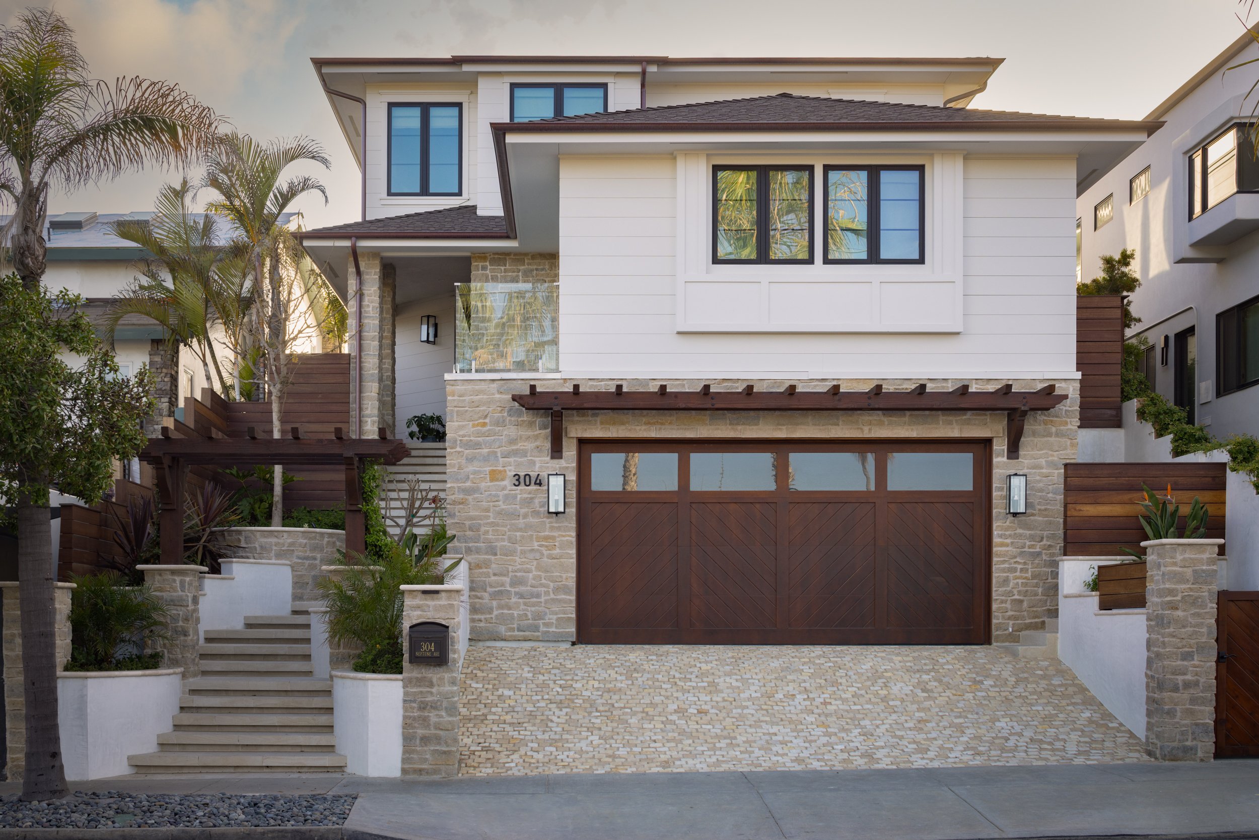 Contemporary coastal-style house with white siding and wooden accents.