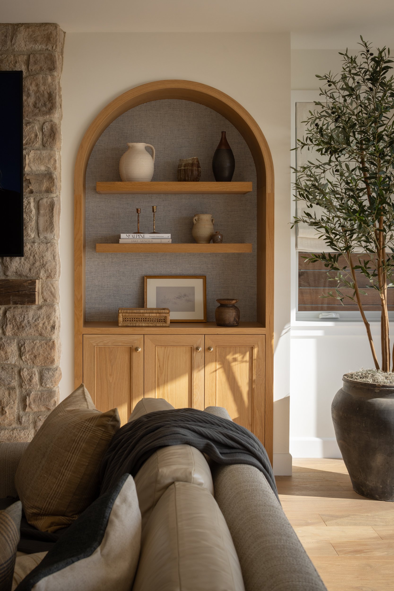 Elegant living room decor featuring built-in wooden shelves with vases and artwork.