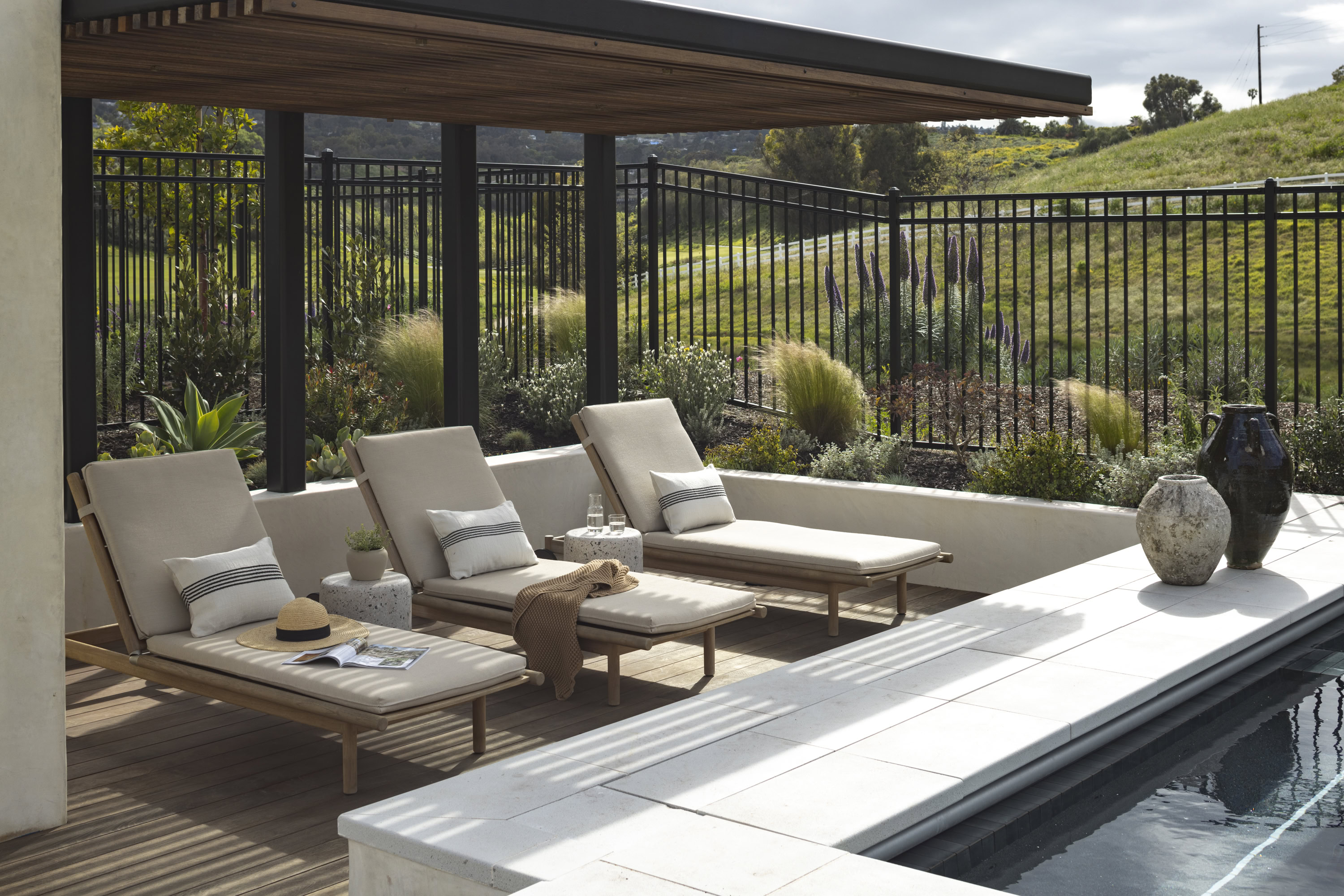 Outdoor lounge with pool and scenic hillside views at Rolling Hills Estates.