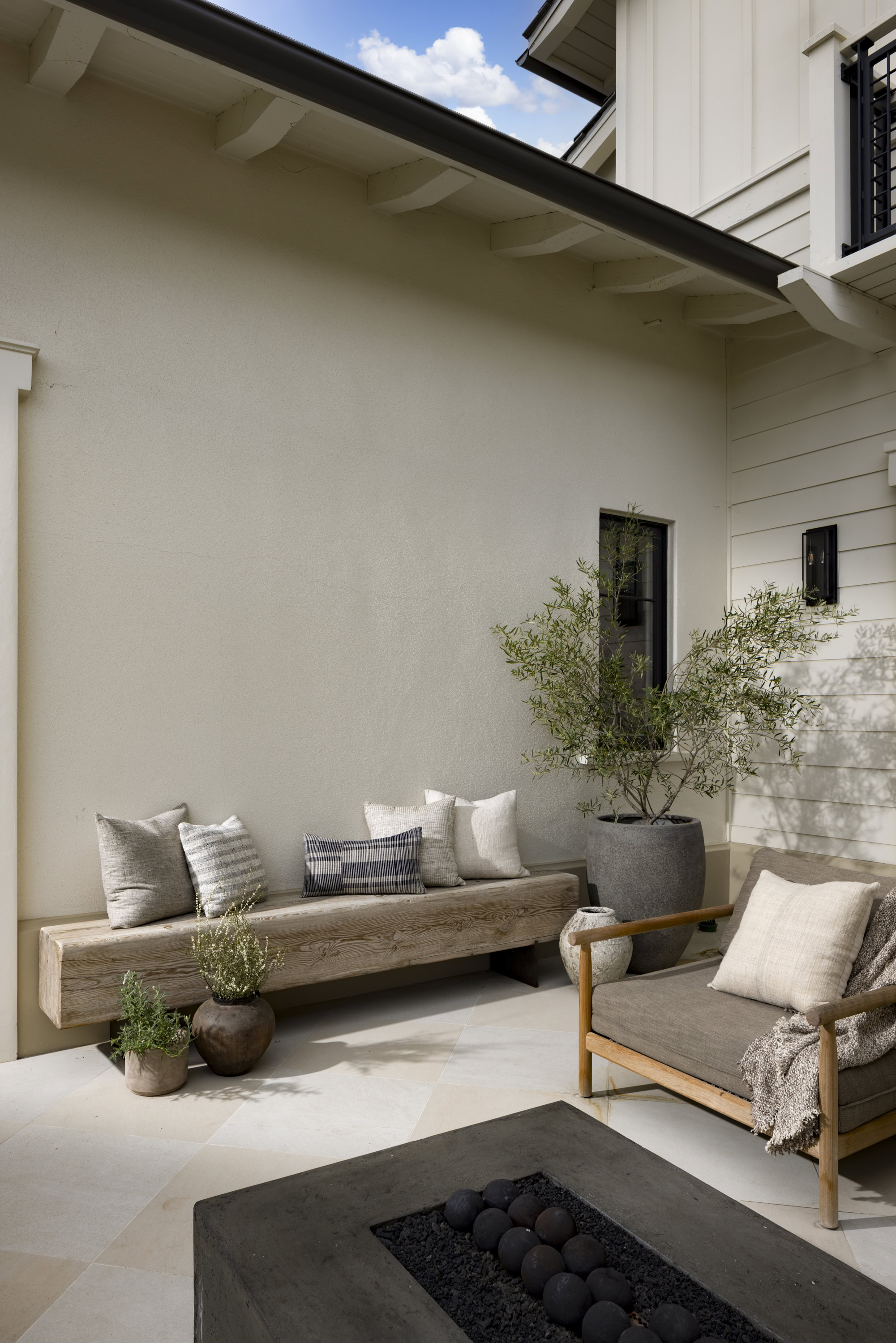 Outdoor patio with comfortable seating, potted plants, and modern decor.