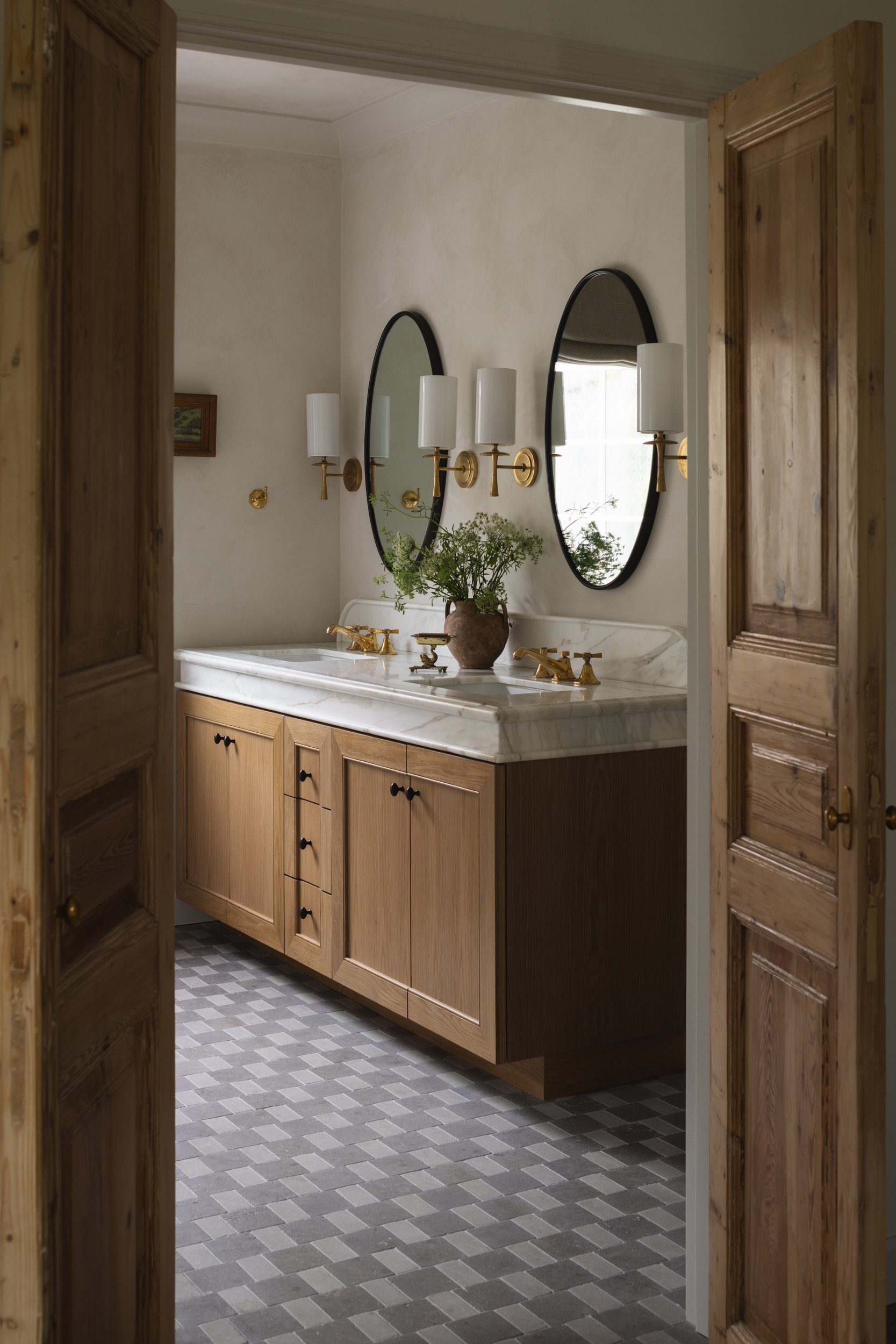 Bathroom vanity with wooden cabinets and dual mirrors for a stylish, functional space.