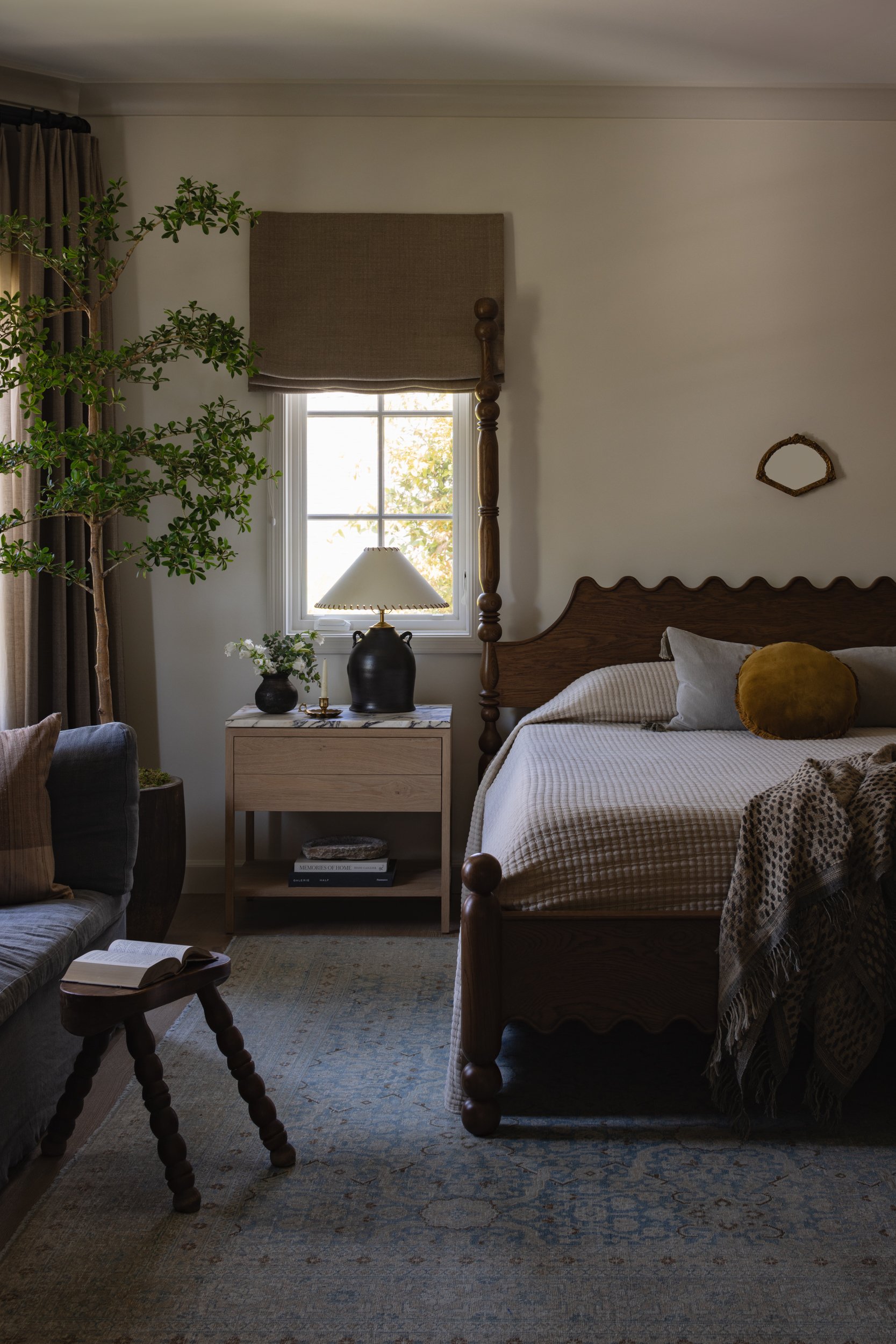 Bright bedroom with large window and elegant decor.