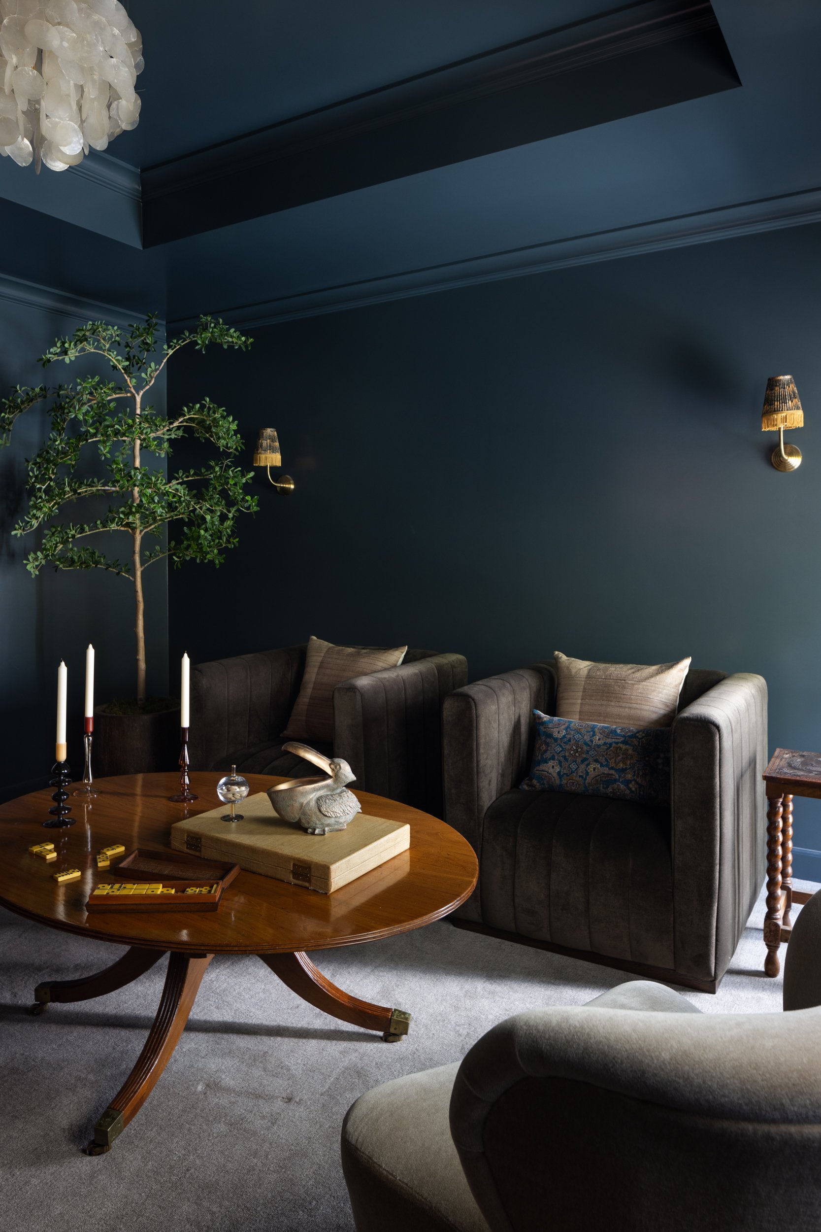 Blue living room with dark walls and cozy seating area.